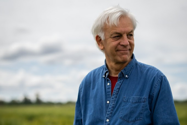 headshot of man standing in field