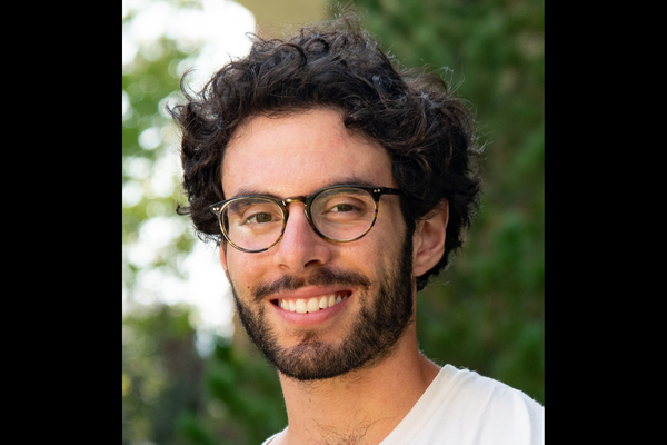 headshot of man wearing glasses outdoors