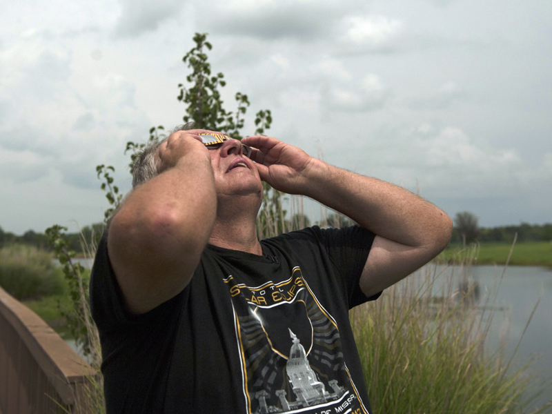 Man looking into sky with glasses on.