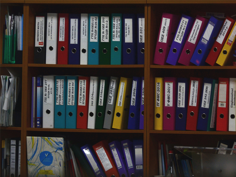 shelves with stacks of colored binders